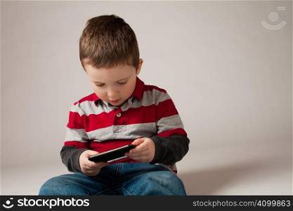 Cute little boy holding a portable video game