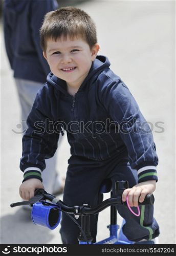 cute little boy outdoor portrait while learning to drive first bicycle