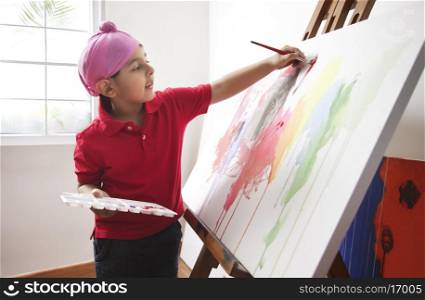 Cute little boy painting on artist's canvas