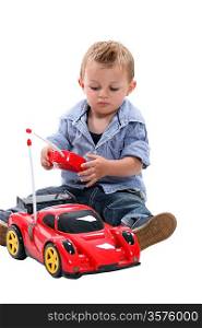 Cute little boy playing with a remote controlled car.