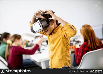 Cute little boy wearing VR virtual reality glasses in a robotics classroom