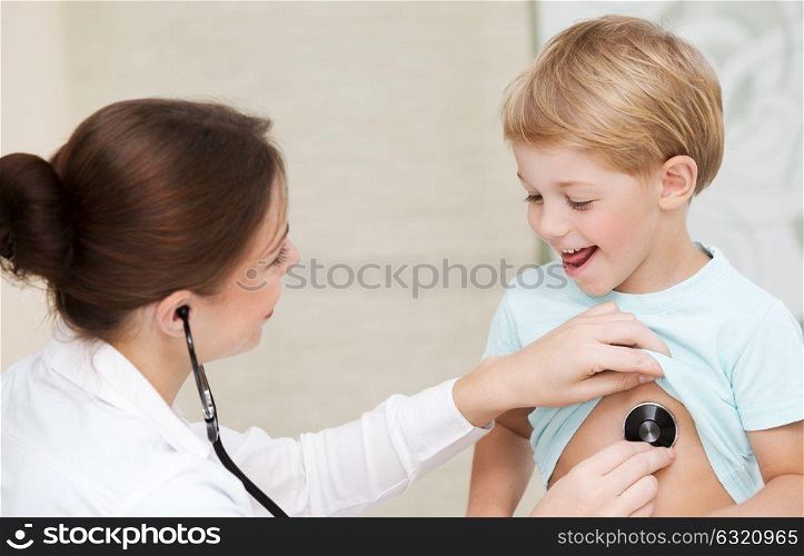 Cute little boy with pleasure visiting pediatrician, scheduled checkup of a baby health, appointment with the family doctor, healthy lifestyle