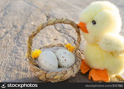 cute little chicken toy and basket with two easter eggs on the stone path - easter concept.. cute little chicken toy and basket with two easter eggs on the stone path - easter concept