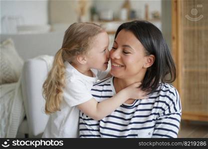 Cute little child girl adopted daughter hugs mom, touching nose to mother&rsquo;s cheek, showing love at home. Family enjoying tender moment together, embracing. Happy adoption, motherhood concept.. Little child girl adopted daughter hugs mom, touching nose to mother&rsquo;s cheek. Happy adoption concept