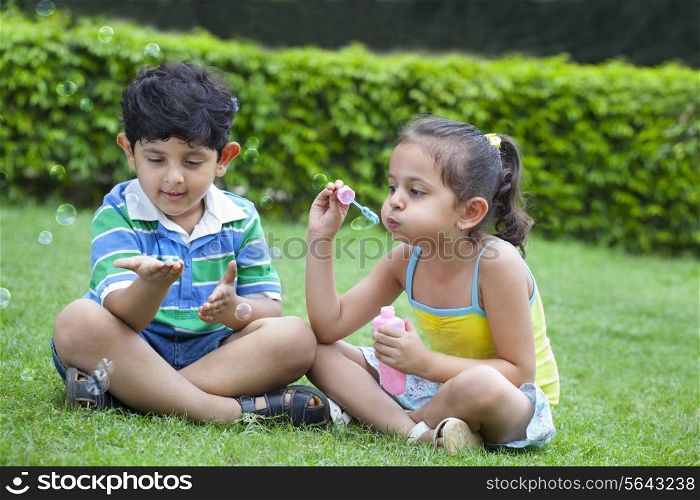 Cute little children playing with bubbles