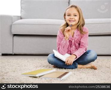Cute little girl at home studying