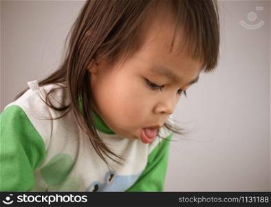 Cute little girl coughing isolated on gray background. Concept of healthcare and medical in child.