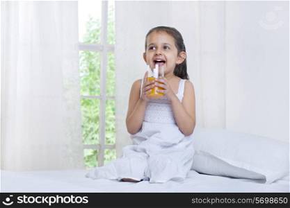 Cute little girl drinking juice
