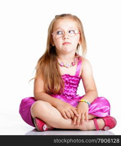 cute little girl glasses sitting on floor looking to the side studio shot isolated on white background