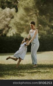 Cute little girl having fun on a grasswith her mother