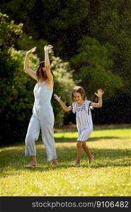 Cute little girl having fun on a grasswith her mother