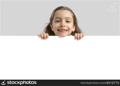 Cute little girl holding a blankboard, with copy space