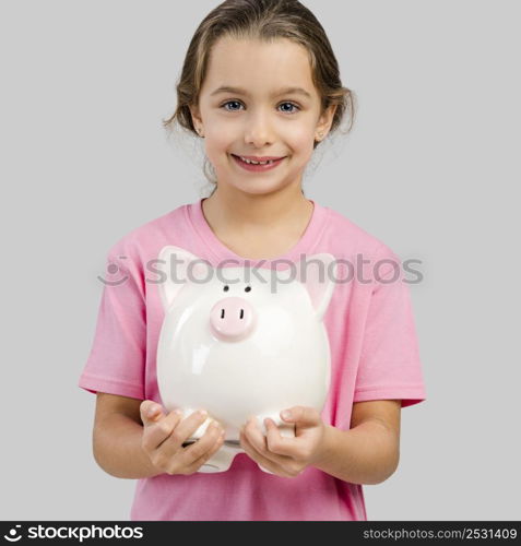 Cute little girl holding a piggybank with her savings