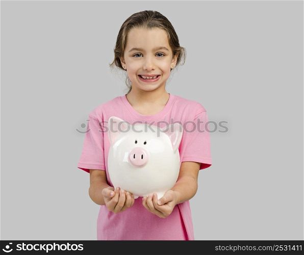 Cute little girl holding a piggybank with her savings