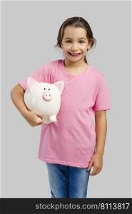 Cute little girl holding a piggybank with her savings