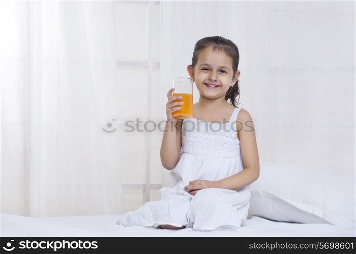 Cute little girl holding glass of juice