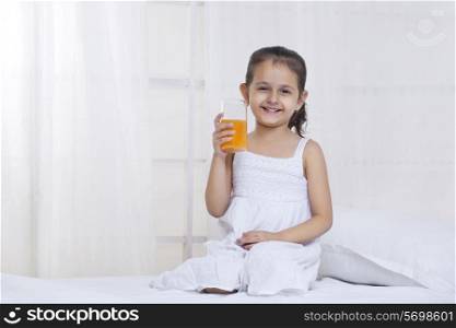 Cute little girl holding glass of juice