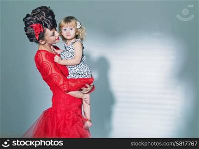 Cute little girl hugged by her elegant mother