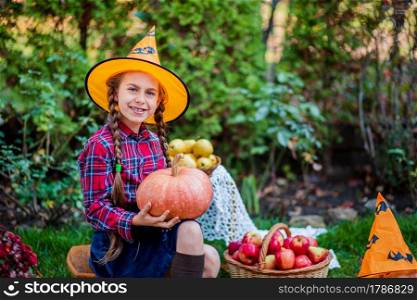 Cute little girl hugs a pumpkin in the autumn garden. Celebrating Autumn Harvest.. Cute little girl hugs a pumpkin in the autumn garden.