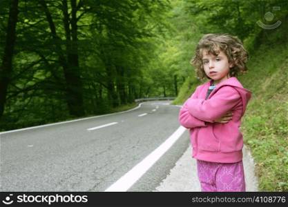Cute little girl in a forest road dress in pink
