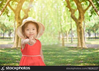 Cute little girl in the green park on a sunny day