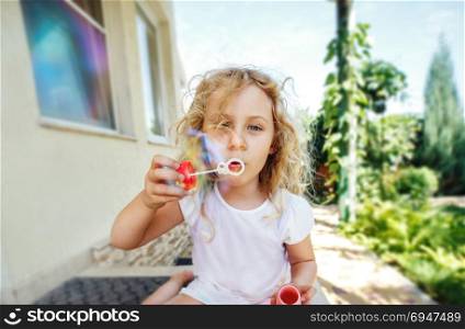 Cute little girl is blowing a soap bubbles.. Cute little girl is blowing a soap bubbles