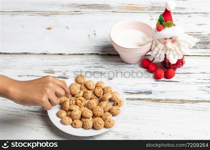 Cute little girl is playing with Santa&rsquo;s cookies and milk at Christmas