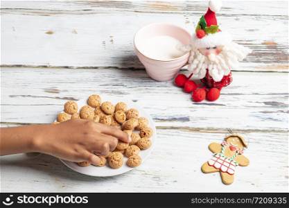 Cute little girl is playing with Santa&rsquo;s cookies and milk at Christmas