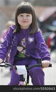 cute little girl learn to drive bicyle at sunny day