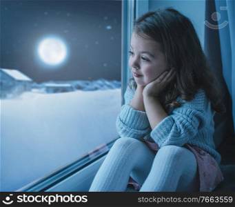 Cute, little girl looking at the moon the winter sky