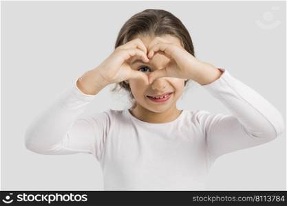 Cute little girl looking through heart shaped hands