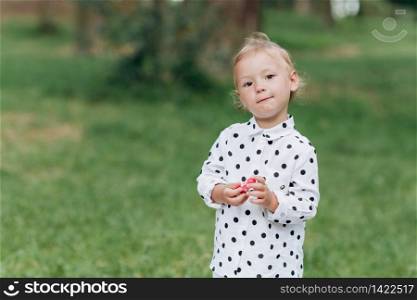 Cute little girl on the grass background in the park in summer day. happy summer holiday. selective focus.. Cute little girl on the grass background in the park in summer day. happy summer holiday. selective focus