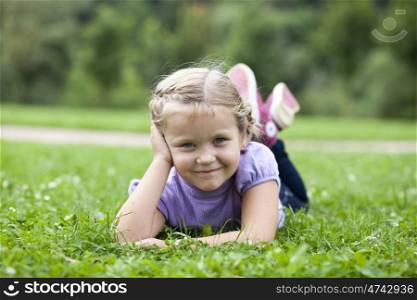 Cute little girl on the meadow in summer day