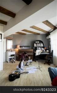 Cute little girl playing guitar with her music teacher in the rustic apartment