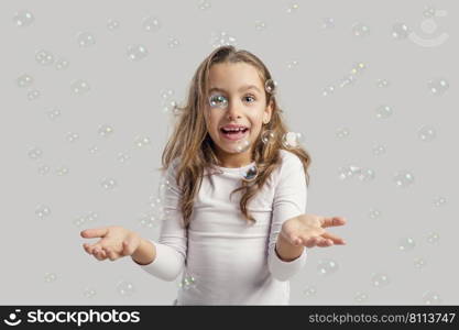 Cute little girl playing with soap bubbles