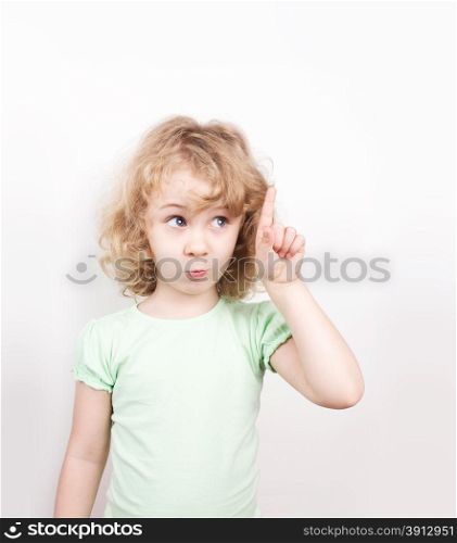 Cute little girl pointing up, copy space