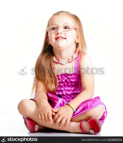 cute little girl sitting on floor and smiling, studio shot isolated on white background
