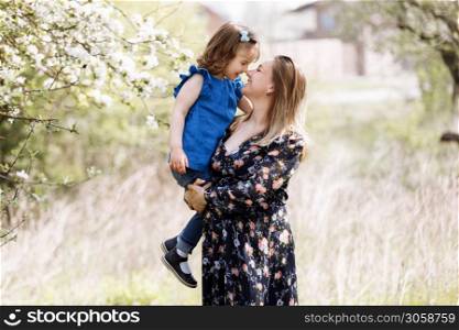 Cute little girl touching her mother&rsquo;s pregnant belly in summer nature.. pregnant mother with daughter in nature. Cute little girl touching her mother&rsquo;s pregnant belly in summer nature