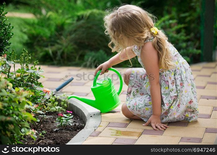 Cute little girl watering plants in the garden. Cute little girl watering plants in the garden.