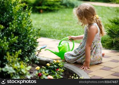 Cute little girl watering plants in the garden.. Cute little girl watering plants in the garden