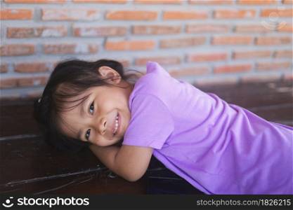 Cute little girl wearing purple clothes is smiling happy