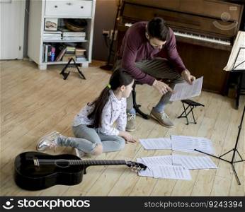Cute little girl with guitar teacher in the room