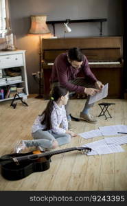 Cute little girl with guitar teacher in the room