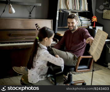 Cute little girl with guitar teacher in the room at home