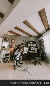 Cute little girl with guitar teacher in the room at home