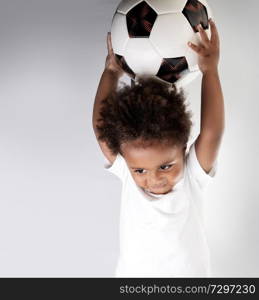 Cute little goalkeeper with soccer ball in hands isolated on clear background, sweet small boy enjoying sport, photo with a copy space, happy active childhood