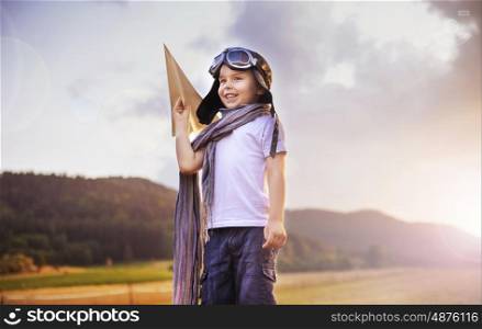 Cute little pilot holding a paper plane