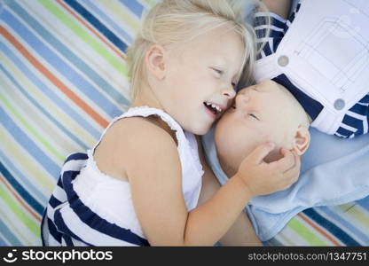 Cute Little Sister Laying Next to Her Baby Brother on Blanket.