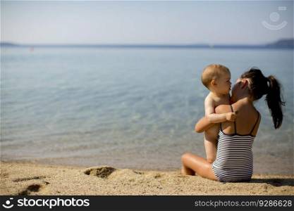 Cute little sisters sitting on a beach at summer