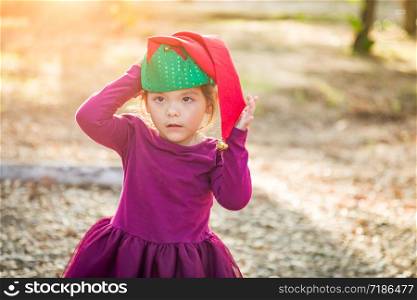 Cute Mixed Race Young Baby Girl Having Fun Wearing Christmas Hat Outdoors.